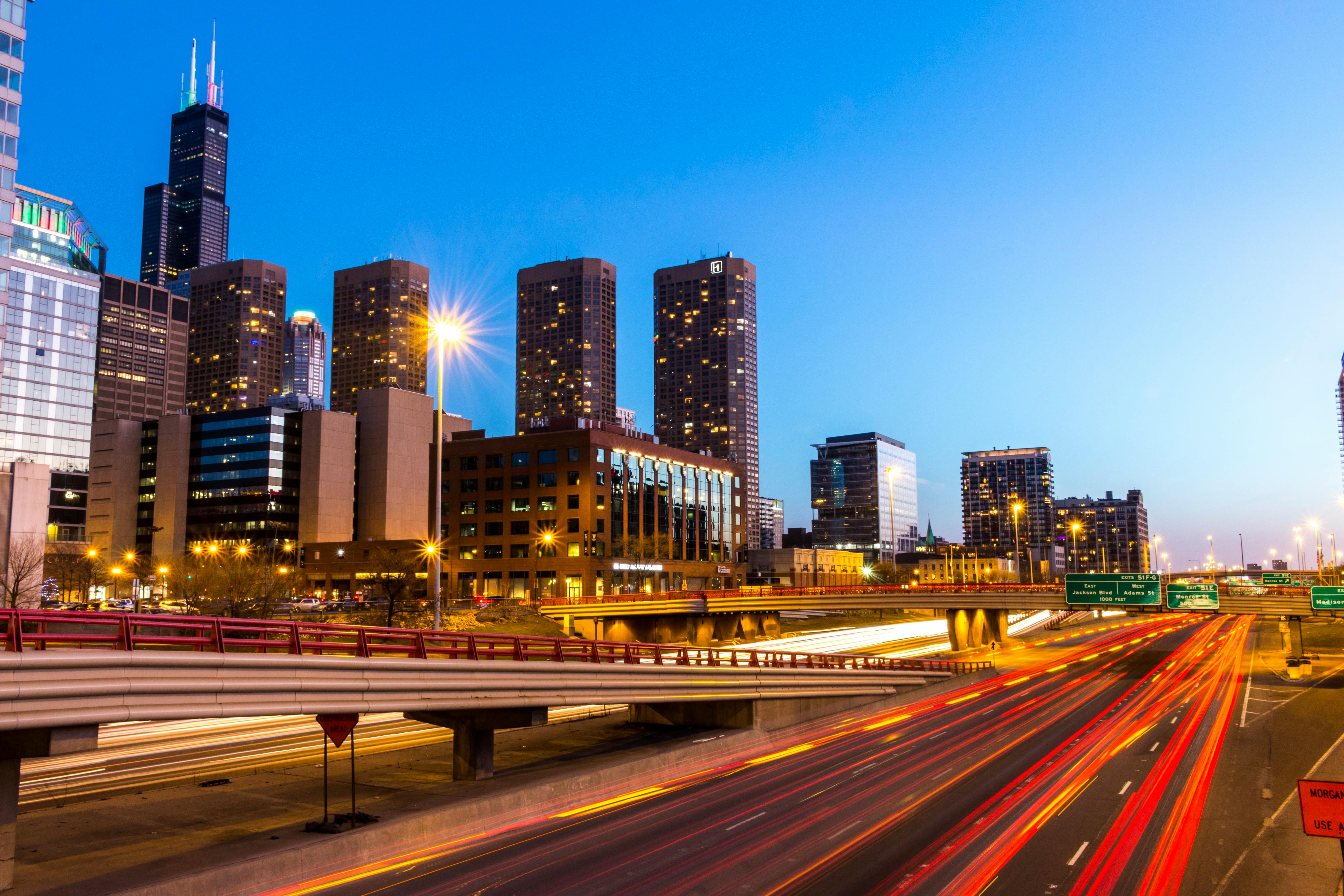 黄昏时分，芝加哥天际线充满活力，明亮的高速公路捕捉到灯光痕迹