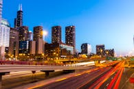 黄昏时分，芝加哥天际线充满活力，明亮的高速公路捕捉到灯光痕迹