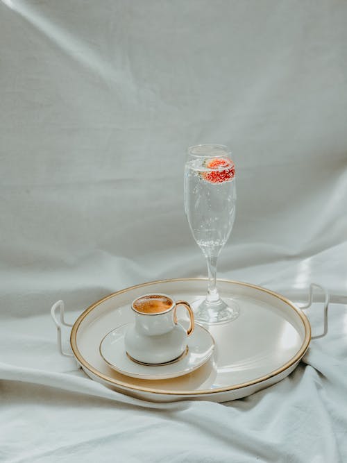 Free Champagne Glass with Sparkling Water and Cup of Coffee on Tray Stock Photo