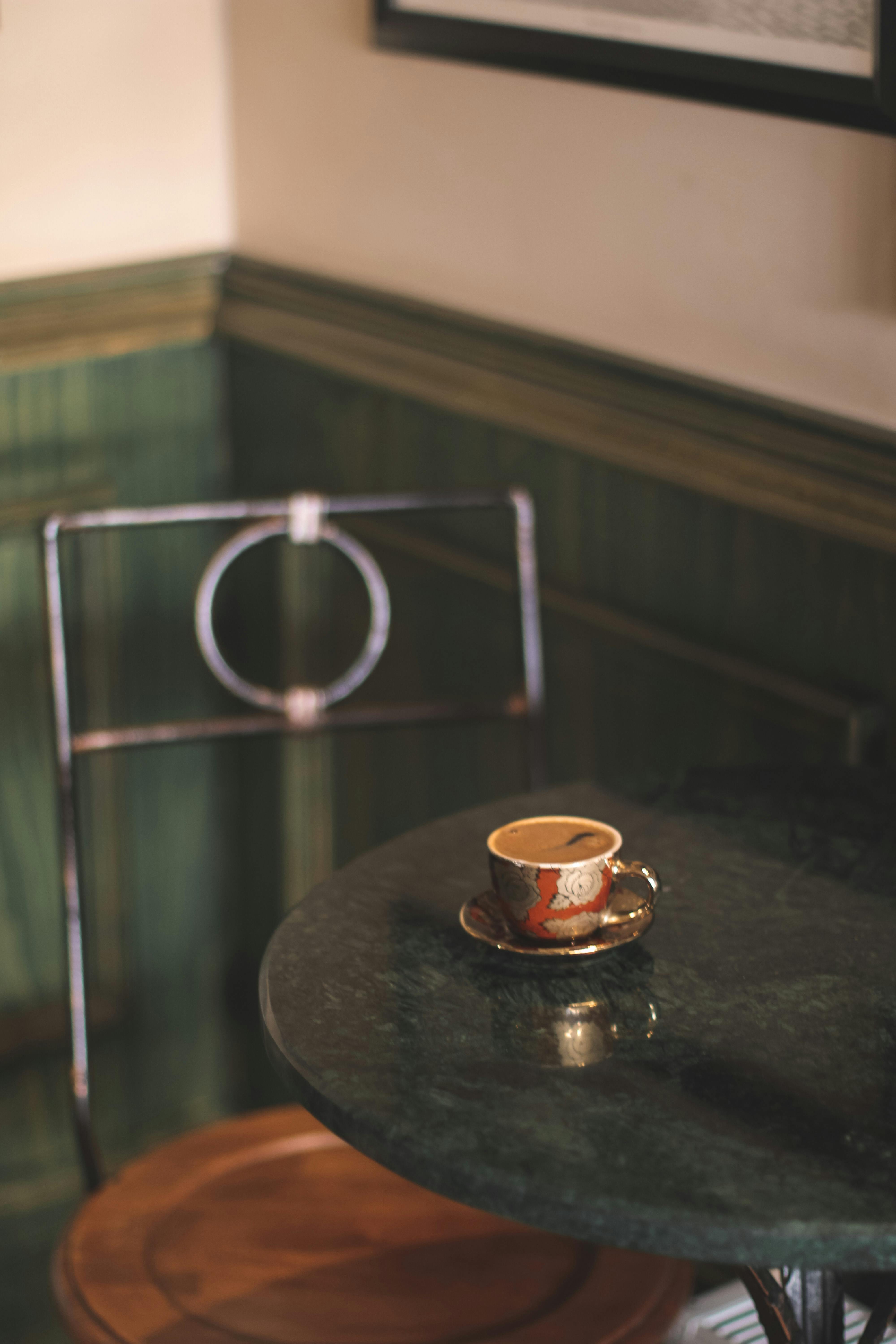 Free Elegant coffee setup in a cozy corner with a decorative mug on a marble table. Stock Photo