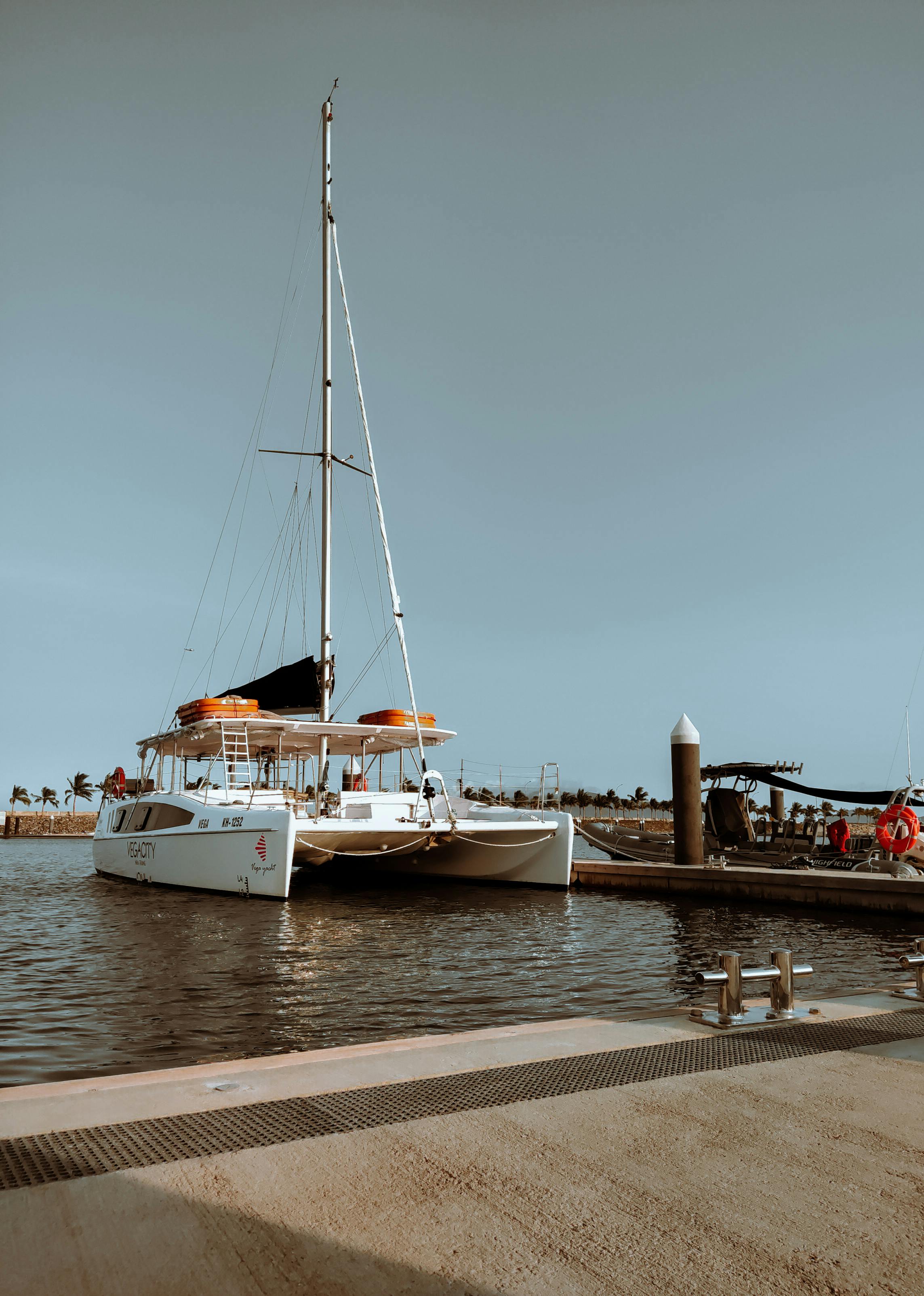 A peaceful yacht docked at a marina under clear blue skies.
