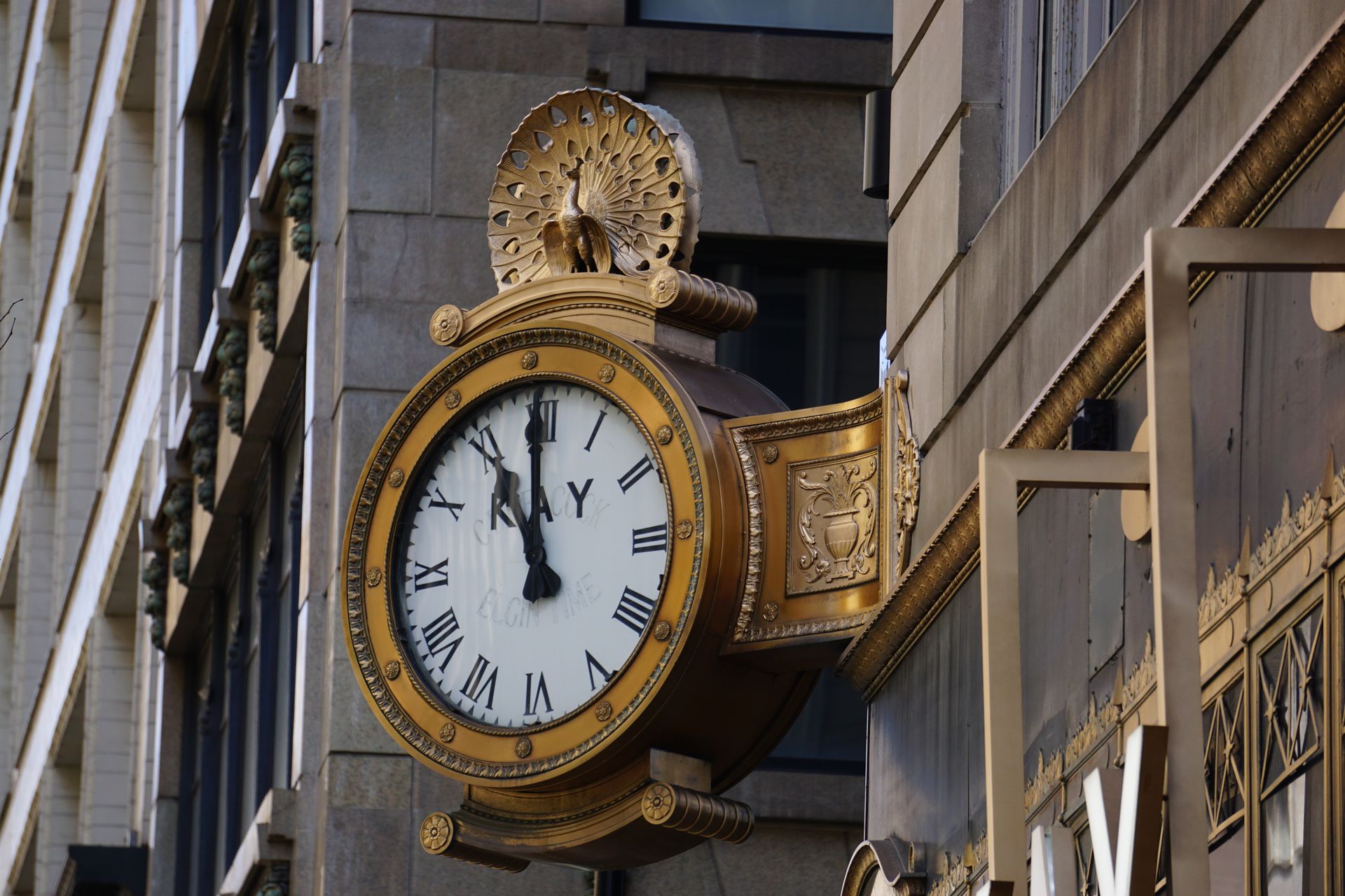 Close-up of an ornate, golden clock on a historic Chicago building facade.