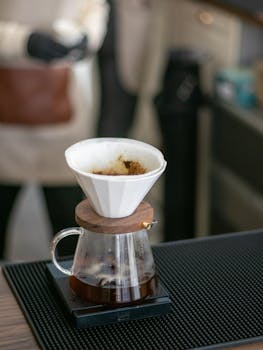 Close-up of a drip coffee setup in a café, showcasing a warm atmosphere.