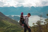 一位父亲带着孩子走在风景优美的山间小路上，拥抱冒险，也拥抱为人父母的时光