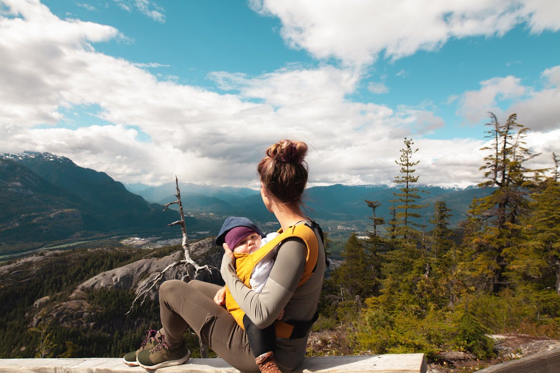 Free Mother Carrying Her Baby while Looking at the Nature Scenery Stock Photo