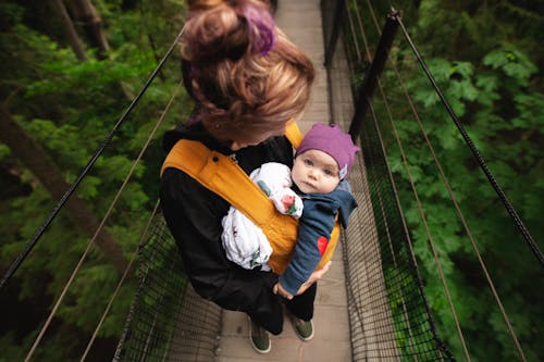 橋の上で赤ちゃんを運ぶ女性