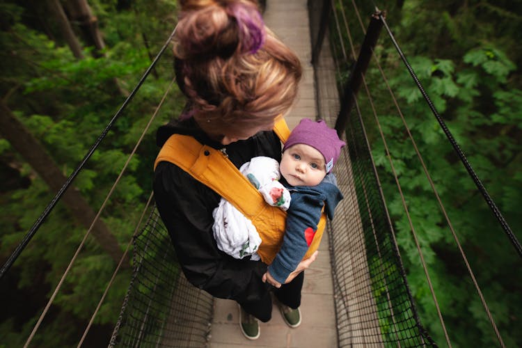 Woman Carrying Baby On Bridge