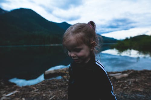 Girl Wearing Black and White Track Jacket Near Body of Water