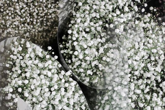From above of identical bouquets with small white blooming flowers with soft texture in buckets with cellophane packaging on top