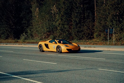 A yellow sports car speeds down a highway in Whistler, Canada on a sunny day.