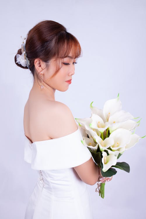 Free Woman in White Tube Dress Holding White Rose Stock Photo