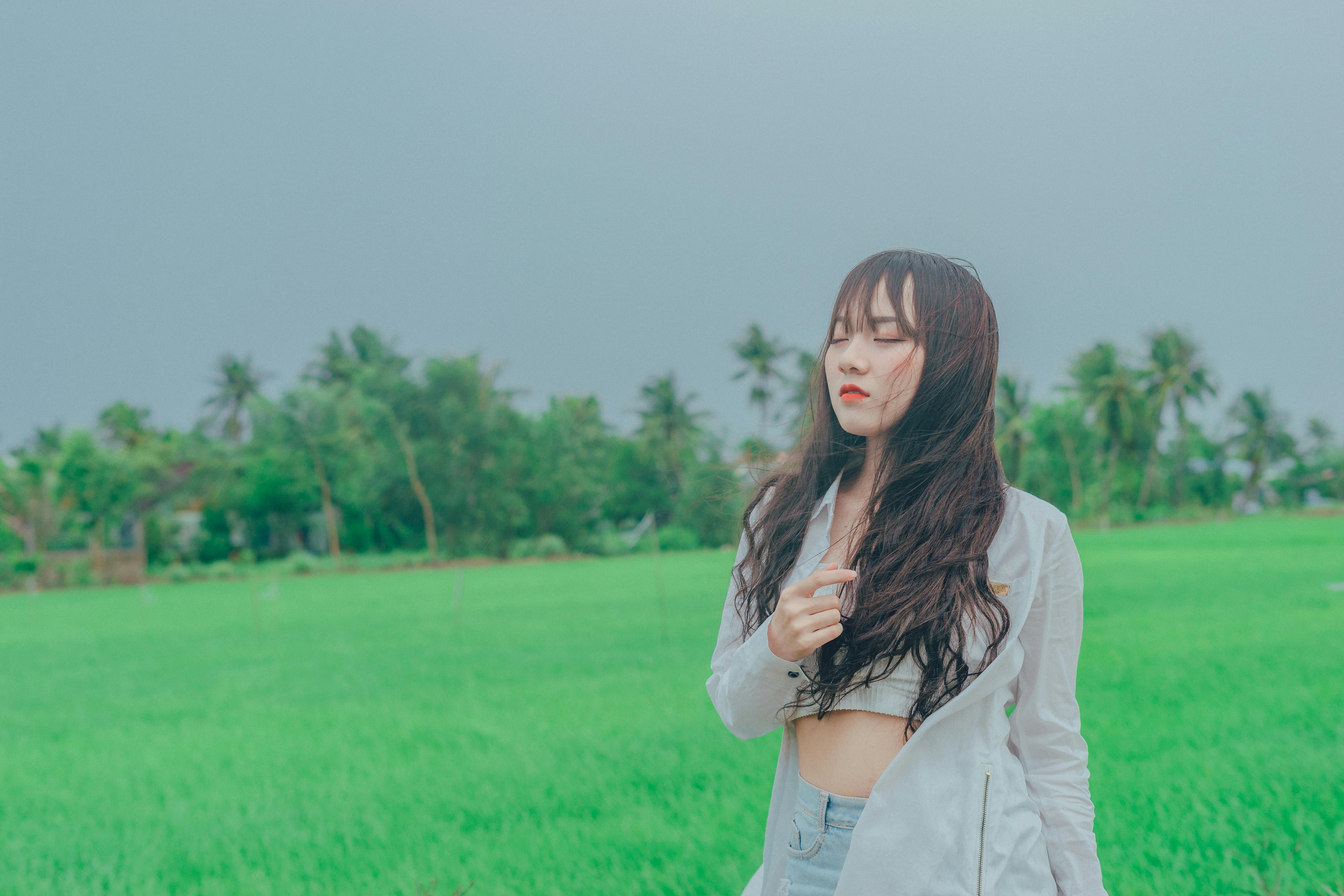 woman wearing gray cardigan on green grass