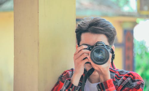 Pria Memegang Kamera Dslr Canon Hitam Yang Diambil