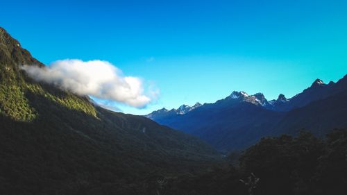 Free Captivating view of lush mountains under a bright blue sky, framed with soft clouds. Stock Photo