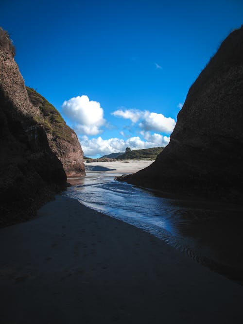 Sandy Beach and Sea between Rock Formations 