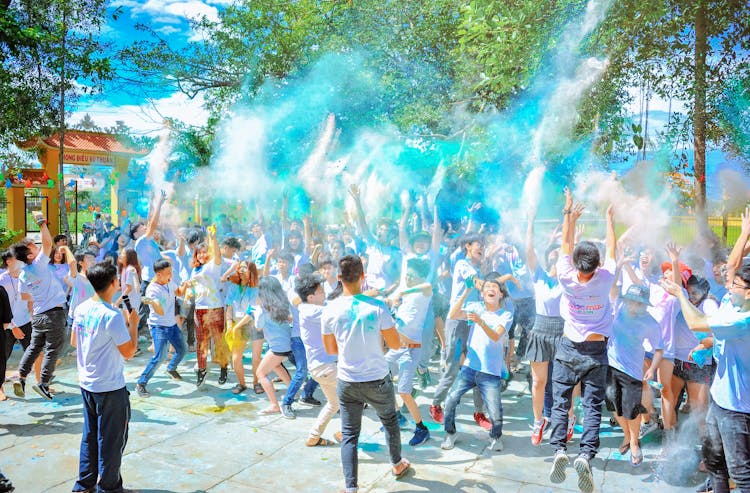 People Throwing Blue Powder At Daytime