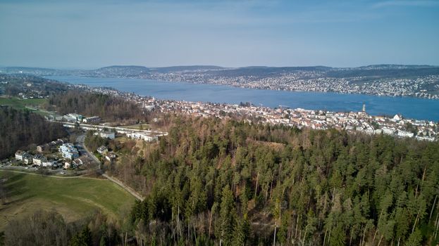 Scenic aerial view of Thalwil in Switzerland with lush forests and Lake Zurich in the background.