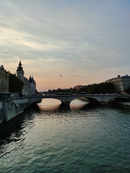 Scenic sunset over the Seine River in Paris showcasing historic bridges and architecture.