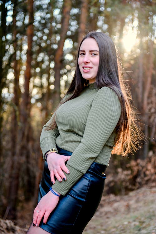 Woman In Green Long Sleeves Standing Near Trees