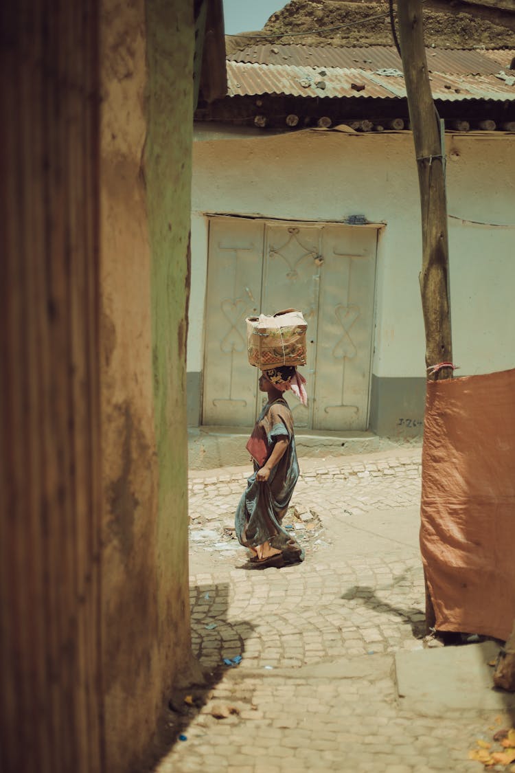 Woman In African Village Carrying Big Package On Head