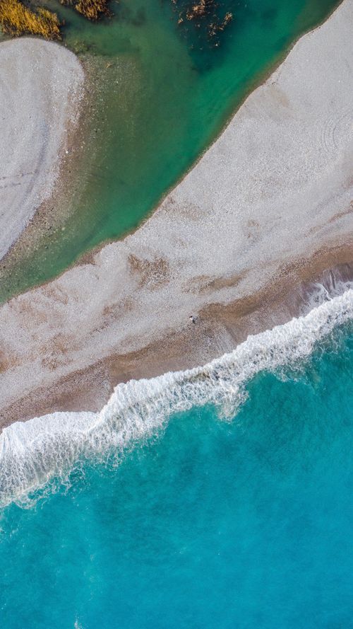Free An aerial view of a picturesque turquoise beach coastline with gentle waves and ample copy space. Stock Photo