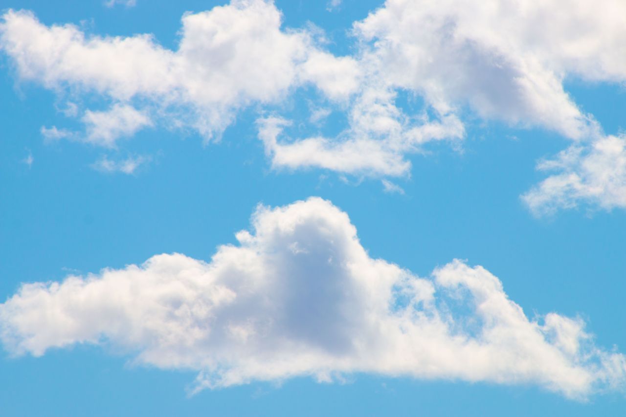 a serene view of fluffy white clouds against a bright blue sky perfect