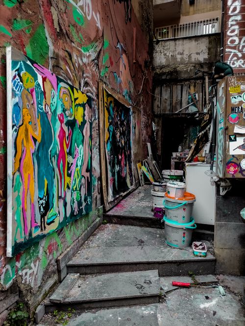 Free Explore this narrow alley filled with vibrant graffiti and colorful murals, showcasing urban street art. Stock Photo