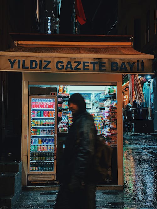 A Person Walking by a Newsstand in Istanbul