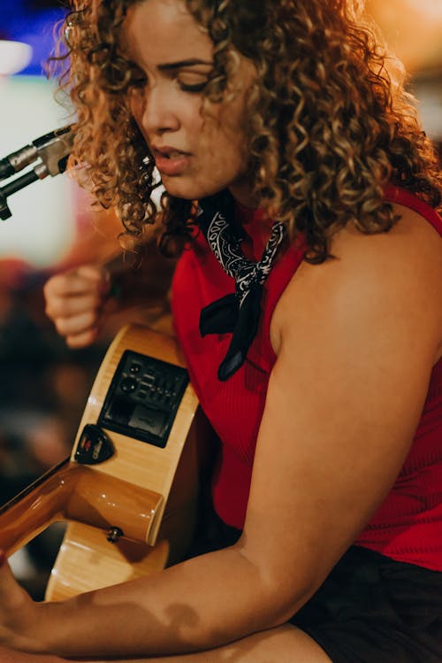 Curly Haired Woman Playing an Acoustic Guitar 