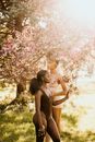 Woman in White Bikini Top Standing Under Pink Cherry Blossom Tree