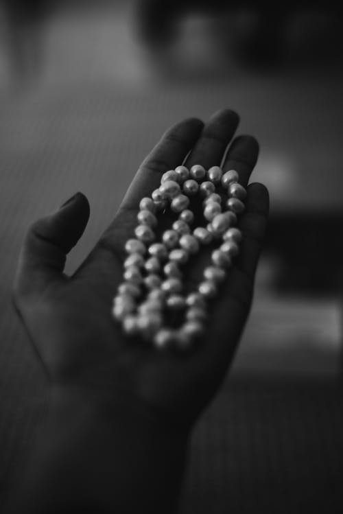 Person Holding a Pearl Necklace