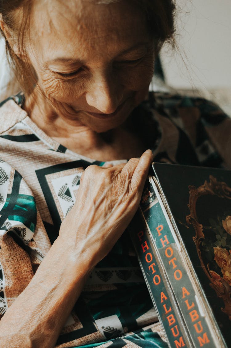 Elderly Woman Holding Photo Albums