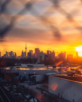 Breathtaking view of Toronto skyline and CN Tower at sunset, showcasing the urban landscape.