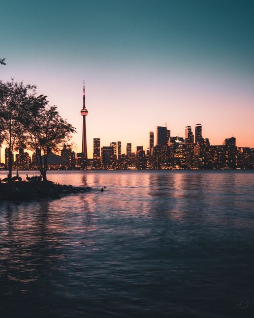 Free Beautiful view of Toronto skyline with CN Tower and waterfront at sunset creating a serene ambiance Stock Photo
