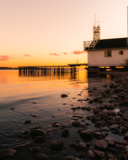 House with Pier by Sea at Sunset