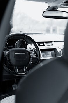Detailed black and white view of a Range Rover interior showcasing the dashboard and steering wheel.