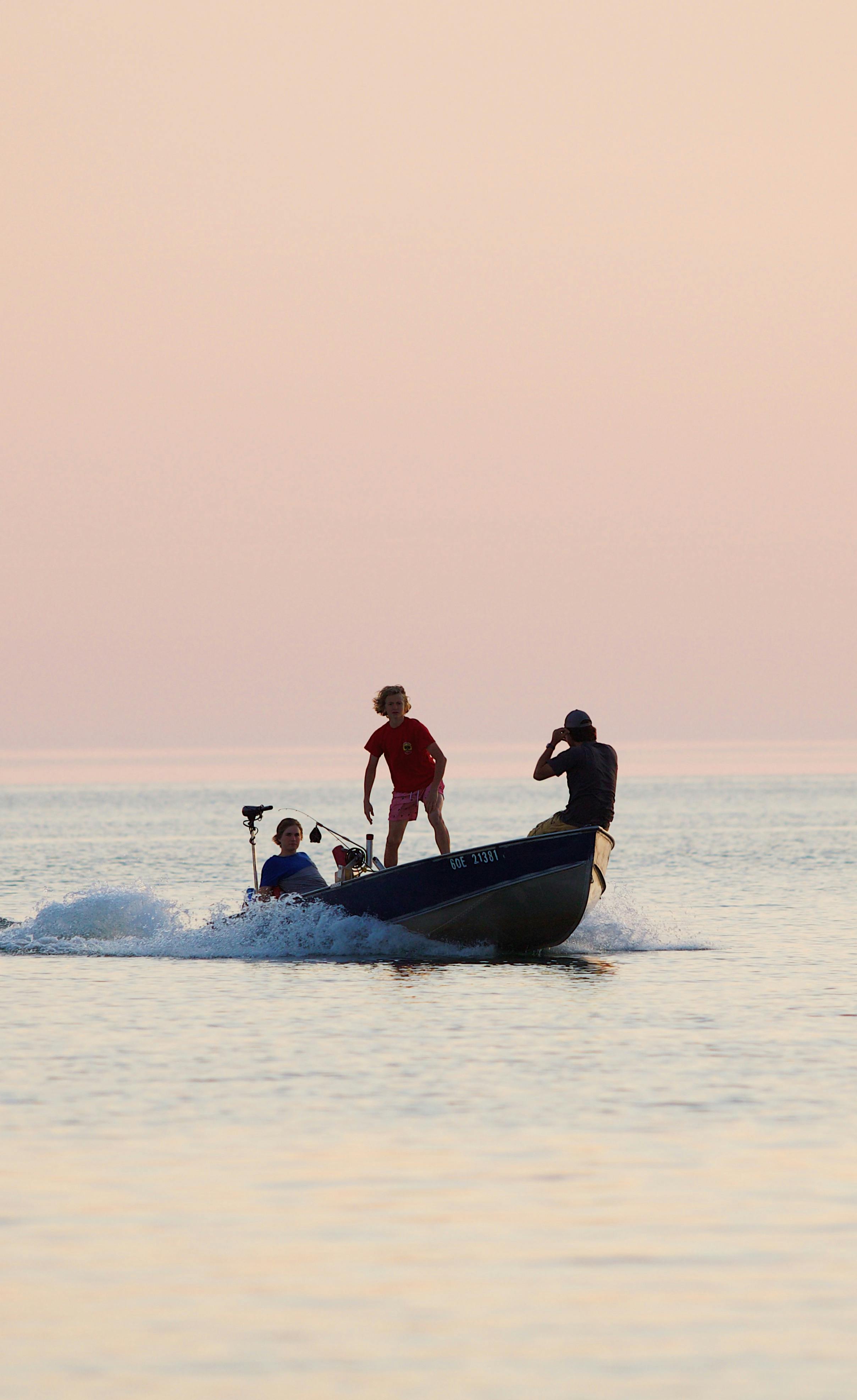 people on a boat at sea under a clear sky