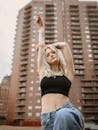 Blond Girl Posing Before Residential High-Rise