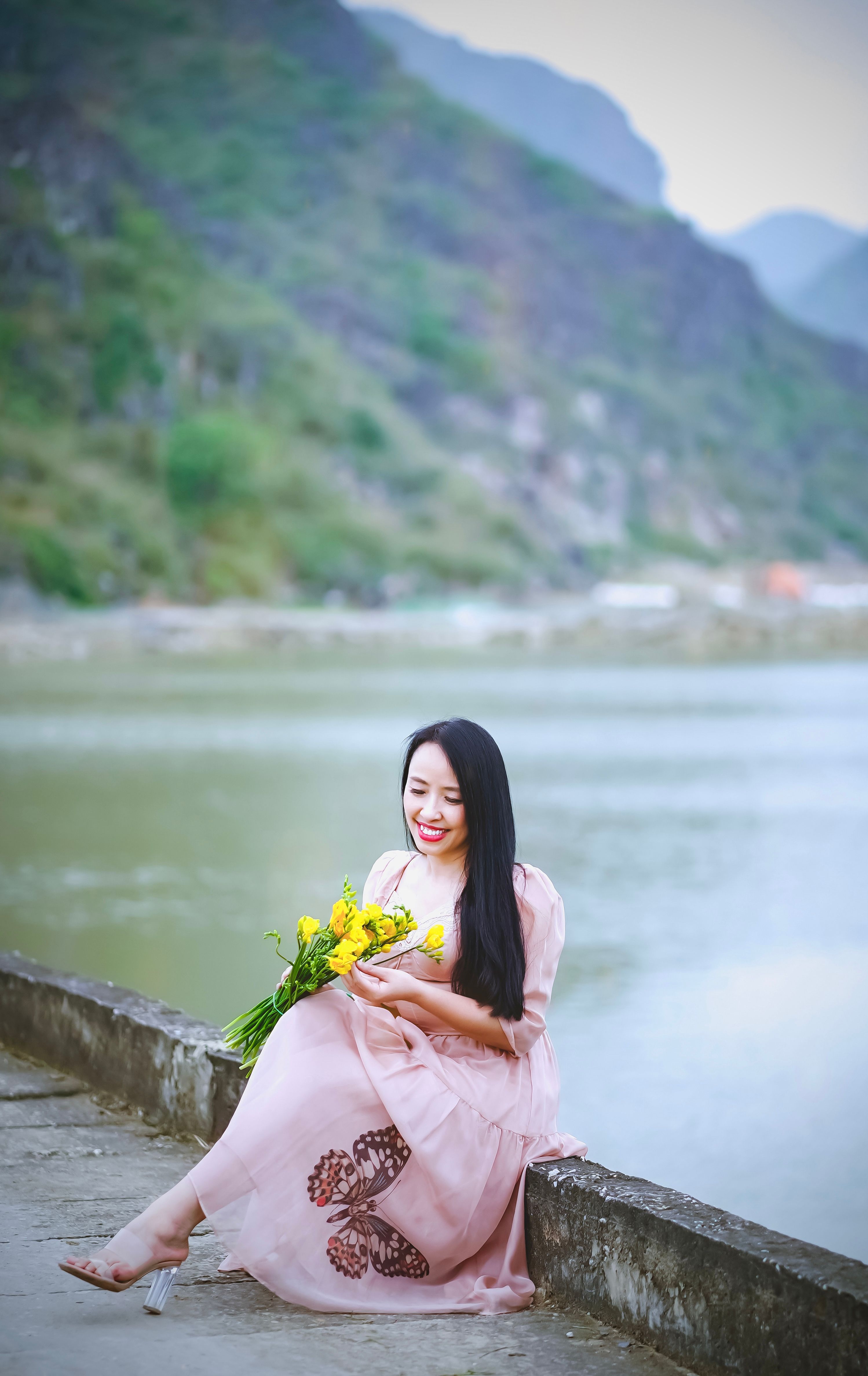 Woman in Pink Dress Holding a Bunch of Flowers · Free Stock Photo