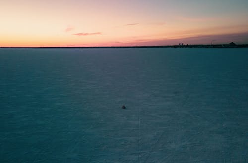 Frozen Lake Under a Clear Sky at Sunset