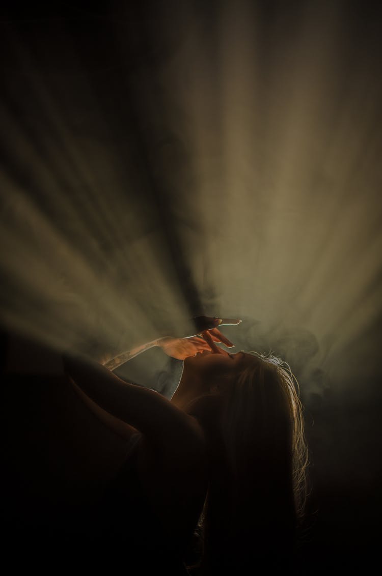 Backlit Portrait Of Woman Lying Back