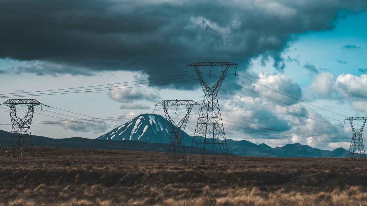 Utility Field Ground Field with Utility Poles and a Volcano in the Background · Free Stock Photo