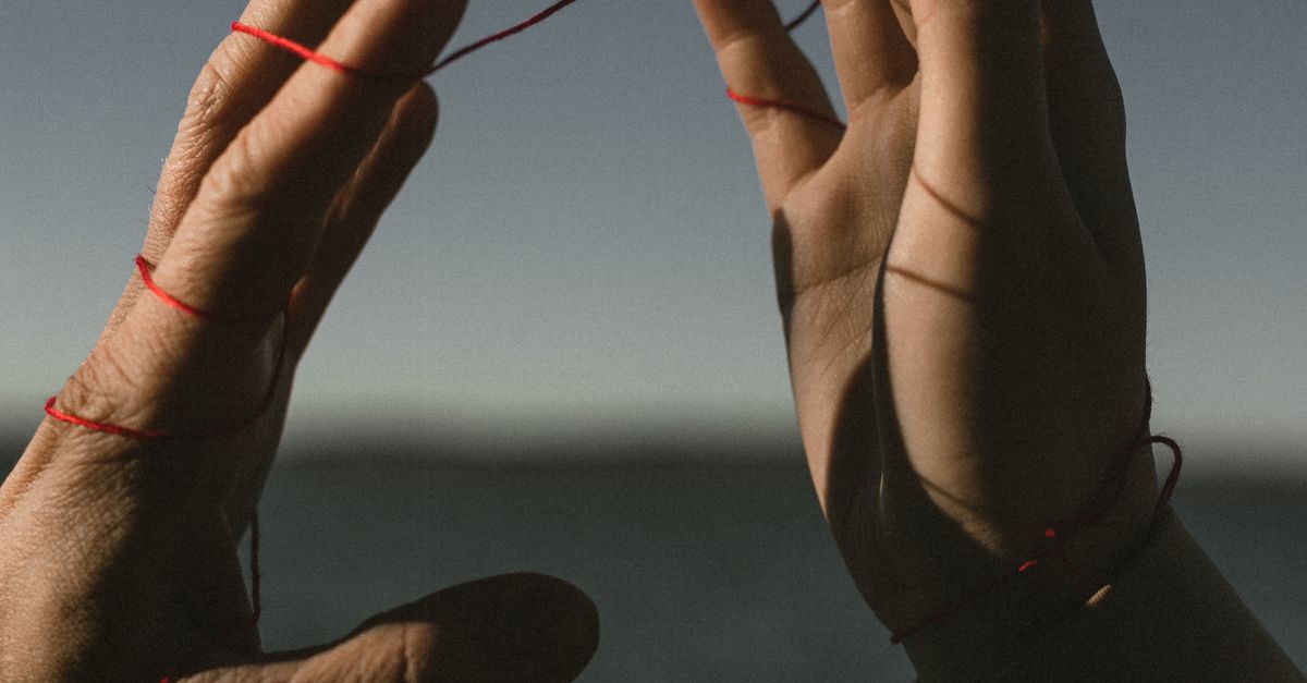 Hands of Couple Connected with Red String · meta.free_stock.photo