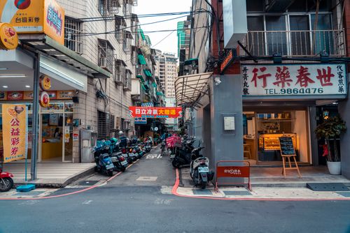 Free Urban street scene with parked motorcycles and local shops in an Asian city. Stock Photo