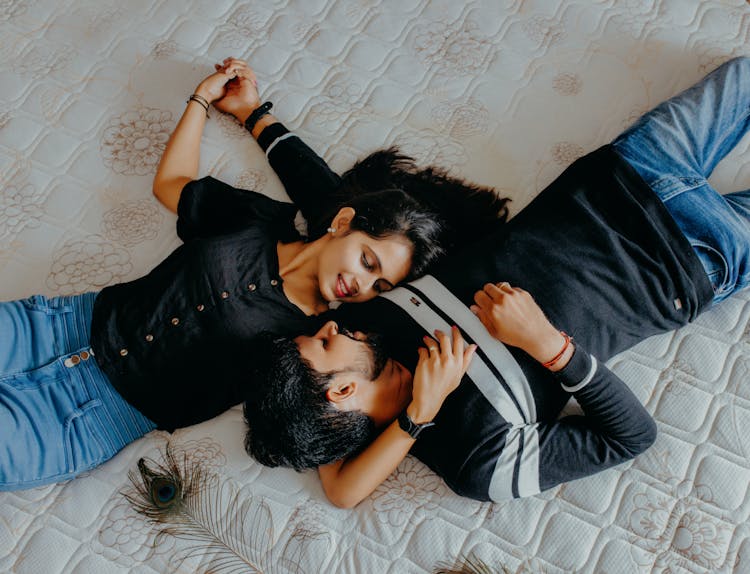 Couple Lying On Bed Looking Into Each Others Eyes