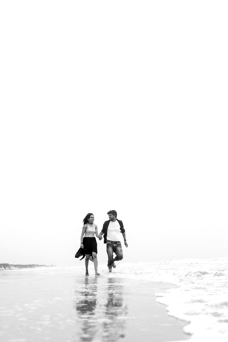 Black And White Couple Walking On Beach