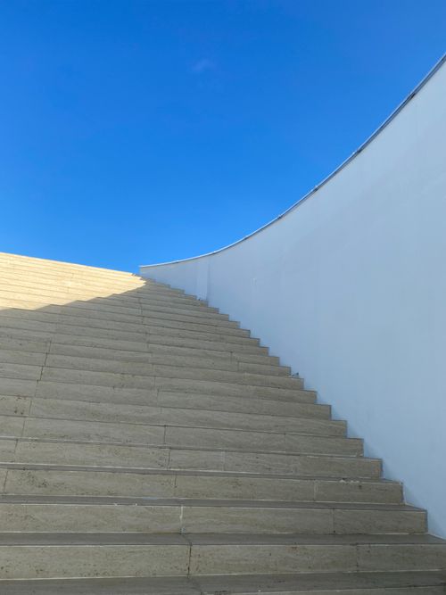 Free A beautiful stone staircase ascending towards a clear blue sky, showcasing modern architecture. Stock Photo