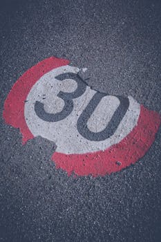 特写镜头中，路面上画着风化严重的30限速标志