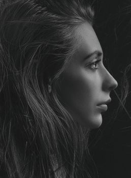 Artistic black and white profile portrait of a woman's face with expressive details.