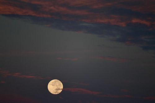 Free A tranquil view of a full moon against a dramatic cloudy sky at night. Stock Photo
